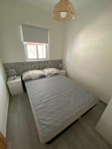 a bedroom with a bed and a window and a mirror at Casa dos Sobreiros in Casas da Ribeira