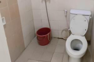 een badkamer met een toilet en een rode emmer bij Hotel Arimbi 3 RedPartner in Bandung