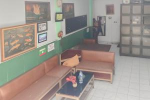 a waiting room with benches and a table and paintings at Hotel Arimbi 3 RedPartner in Bandung
