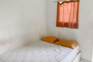 a small bed in a room with a window at Hotel Arimbi 3 RedPartner in Bandung