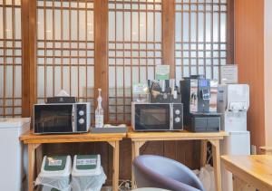 una mesa con microondas y electrodomésticos encima en J2 Family Hotel, en Jeju