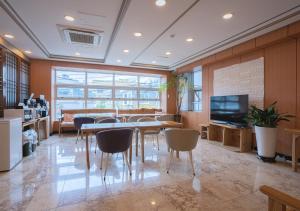 a dining room with a table and chairs and a television at J2 Family Hotel in Jeju