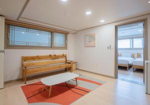 a living room with a bench and a table at J2 Family Hotel in Jeju