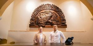 dos hombres parados frente a una mesa con una escultura en Hacienda El Santuario San Miguel de Allende, en San Miguel de Allende