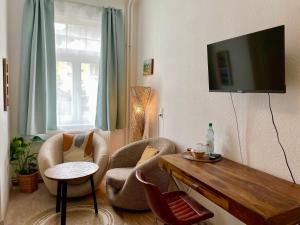 a living room with two chairs and a flat screen tv at Gästehaus Ambiente am Kurpark in Bad Sooden-Allendorf