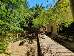 a walkway with a table and chairs and trees at Superbe bâtisse de caractère, coeur de ville in Perpignan