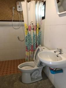 La salle de bains est pourvue de toilettes et d'un lavabo. dans l'établissement บ้านกลางเกาะ รีสอร์ท, à Uthai Thani