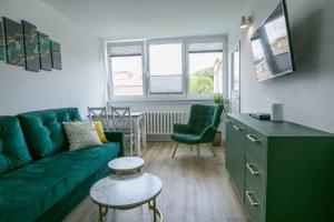 a living room with a green couch and a table at Duszniki Zdrój 1 in Duszniki Zdrój