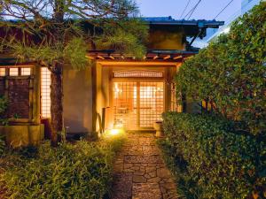 a pathway leading to a house with a tree at Kappo Ryokan Yumesaki in Beppu