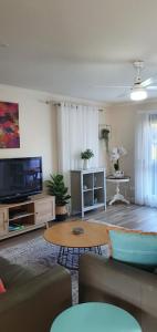 a living room with a couch and a tv at Abalone Guest Accommodation in Lakes Entrance