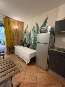 Habitación pequeña con cama y nevera. en L’anthurium en Saint-Paul