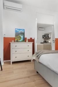 a bedroom with a white bed and a dresser at VD Boutique Apartments No 2 in Bucharest