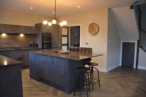 a kitchen with a large island with bar stools at The Bunkhouse - 2 bedroom home with parking in Worcester