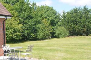 een tafel en stoelen in een tuin met een veld bij The Bunkhouse - 2 bedroom home with parking in Worcester