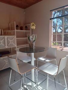 a dining room with a round table and chairs at "O Sole Mio" Self catering studio apartment in Bedfordview in Bedfordview