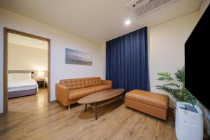 庆州MTM Family Hotel的有一张沙发、一张桌子和一张床的房间
