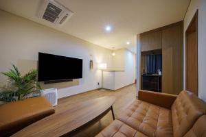 a living room with a couch and a flat screen tv at MTM Family Hotel in Gyeongju