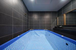 a bathroom with a blue bath tub in a room at MTM Family Hotel in Gyeongju