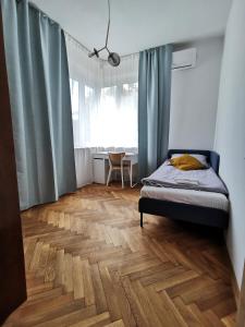 1 dormitorio con 1 cama y suelo de madera en Apartament z klimatyzacją en Cracovia