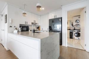 a large kitchen with white cabinets and a large island at Southbank Melbourne Gem in Melbourne