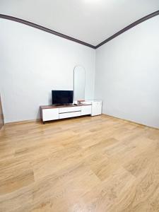 a white room with a tv and a wooden floor at Myungsung Youth Town in Gyeongju
