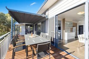 een eethoek in de openlucht met een tafel en stoelen op een terras bij Rye Treetop Retreat in Rye