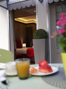 a table with a plate of fruit and a glass of orange juice at Alexandra in Lyon