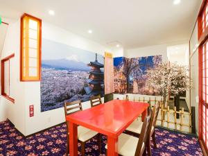 a dining room with a red table and a mountain mural at 沖縄の宿 行燈 あんどん in Naha