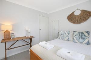 a bedroom with a bed with a nightstand and a lamp at Hillside Farm in Mittagong