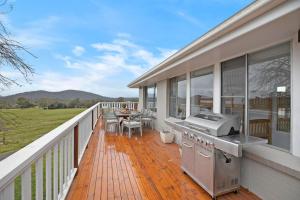 a patio with a grill and a table on a deck at Hillside Farm in Mittagong