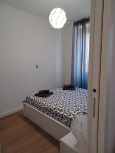 ein kleines Schlafzimmer mit einem Bett mit einer schwarzen und weißen Bettdecke in der Unterkunft Apartman B & S with a beautiful terrace in Pula