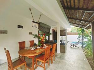 a dining room with a wooden table and chairs at Villa North Coast in Trou aux Biches