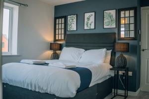 una camera da letto con un grande letto con pareti e finestre blu di Mersey House By Horizon Stays a Redcar