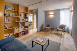 a living room with a blue couch and a book shelf at Luzern Youth Hostel in Lucerne