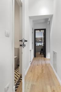 an empty hallway with white walls and wood floors at VD Boutique Apartments No 3 in Bucharest