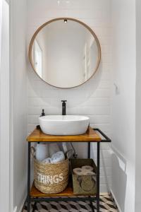 een badkamer met een wastafel en een spiegel bij VD Boutique Apartments No 3 in Boekarest