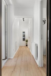 an empty hallway with white walls and a hard wood floor at VD Boutique Apartments No 3 in Bucharest