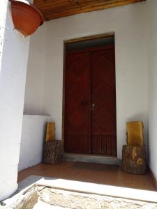 una puerta de madera de una casa con 2 sillas en Casa Ersilia, en Novi Velia