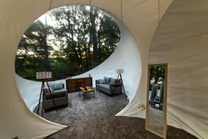 a living room in a tent with a round window at Nomad Hotel & Glamping in Noszvaj
