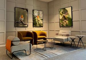 a room with chairs and tables and paintings on the wall at Le Vert Boutique Hotel in Genting Highlands