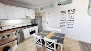 a kitchen with a table and white cabinets at La Casita del Arco Panorámico in San Pedro