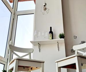 a bottle of wine on a shelf in a room with two chairs at La Casita del Arco Panorámico in San Pedro