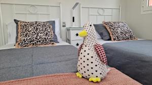 a bedroom with two beds with a toy chicken sitting on a rug at La Casita del Arco Panorámico in San Pedro