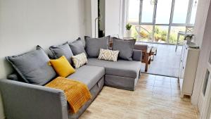 a living room with a gray couch with yellow pillows at La Casita del Arco Panorámico in San Pedro