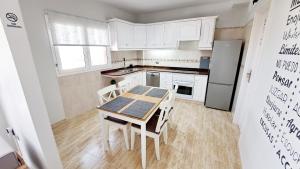 a kitchen with a table and chairs and a refrigerator at La Casita del Arco Panorámico in San Pedro