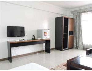 Sky Hotel Nairobi في نيروبي: غرفة معيشة مع تلفزيون ومكتب