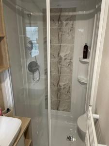 a shower with a glass door in a bathroom at Mersea Villa in West Mersea +25 photos