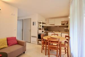 uma sala de estar com uma mesa e um sofá e uma cozinha em CG APPART**4 PERS VUE GAVE BALCON 5 MN LUZ em Luz-Saint-Sauveur