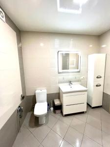a bathroom with a white toilet and a sink at Chornovola Apartment Липинського 28 in Lviv