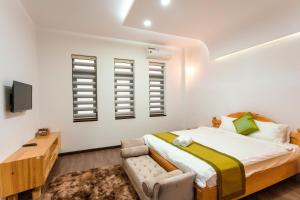 1 dormitorio con 1 cama, TV y ventanas en Khách sạn Minh Anh, en Tuy Hoa